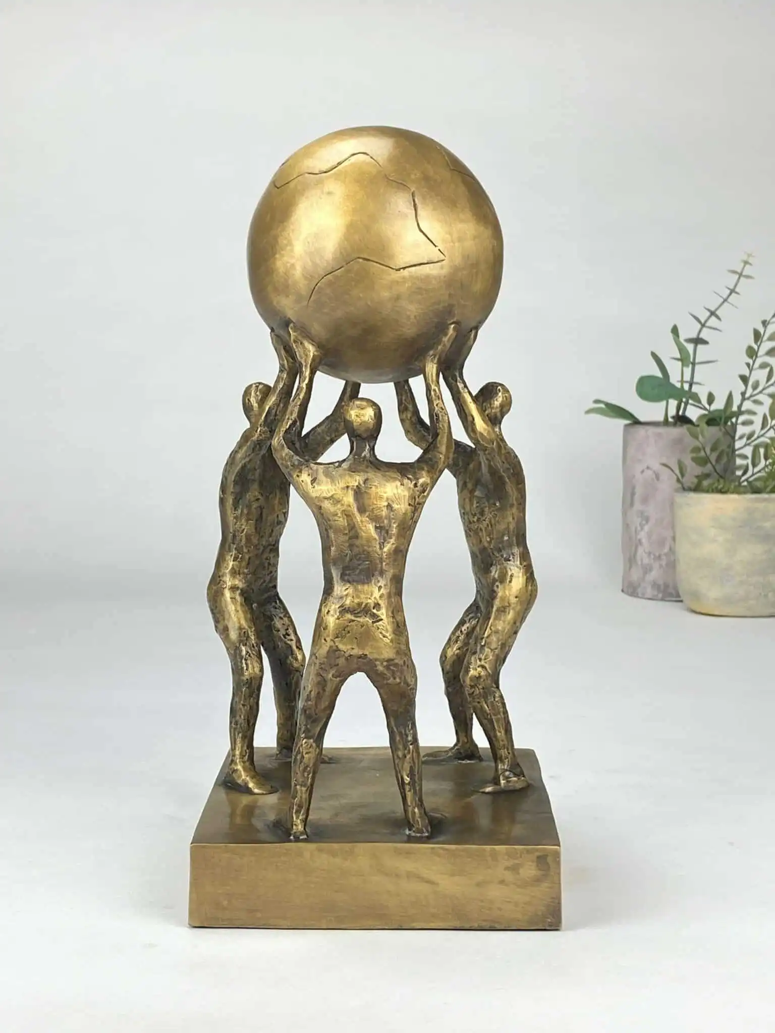 Løfter i flok bronzeskulptur (fællesskab og samarbejde)