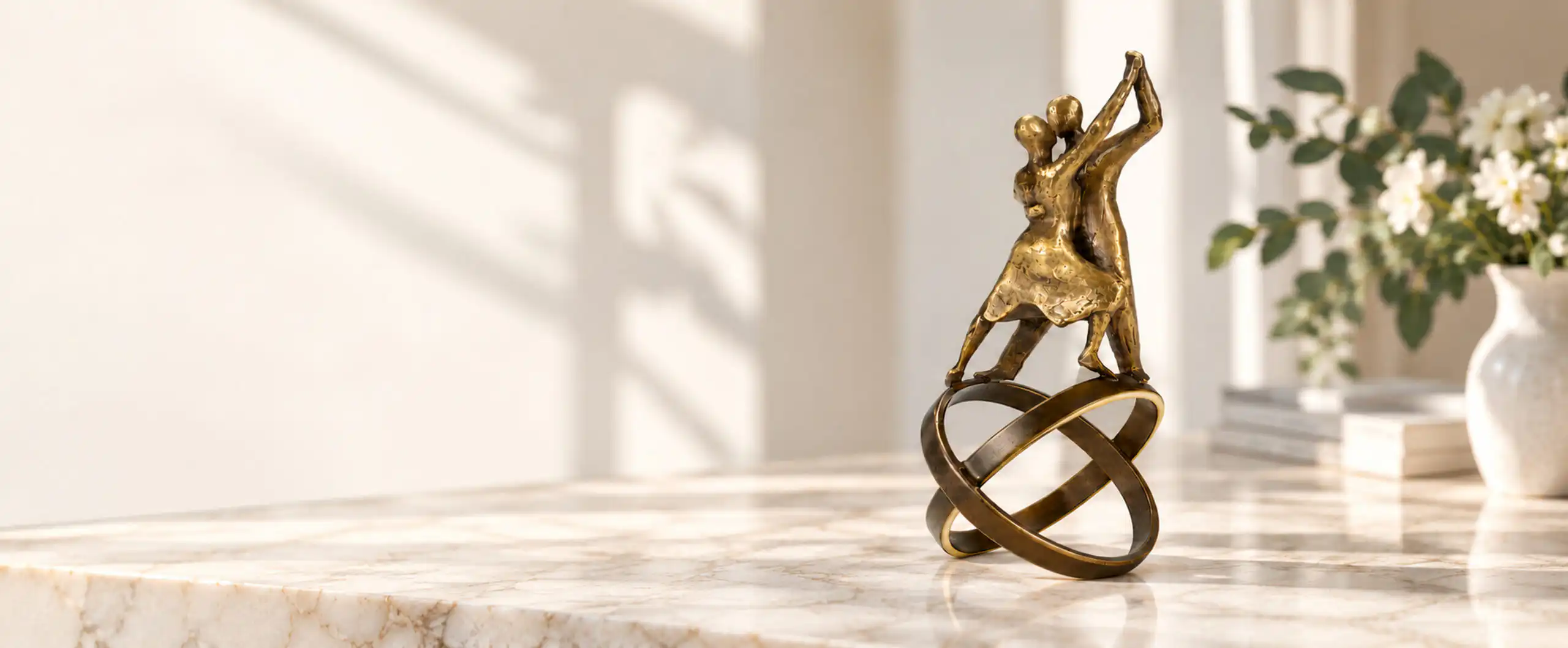 Bronzeskulptur af dansende par på to sammenflettede ringe